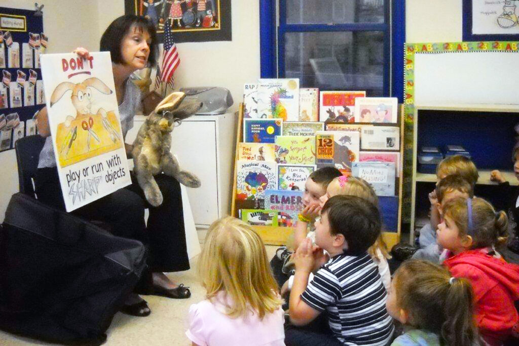 Picture of an agency team member presenting the C. Well Bunny program to children