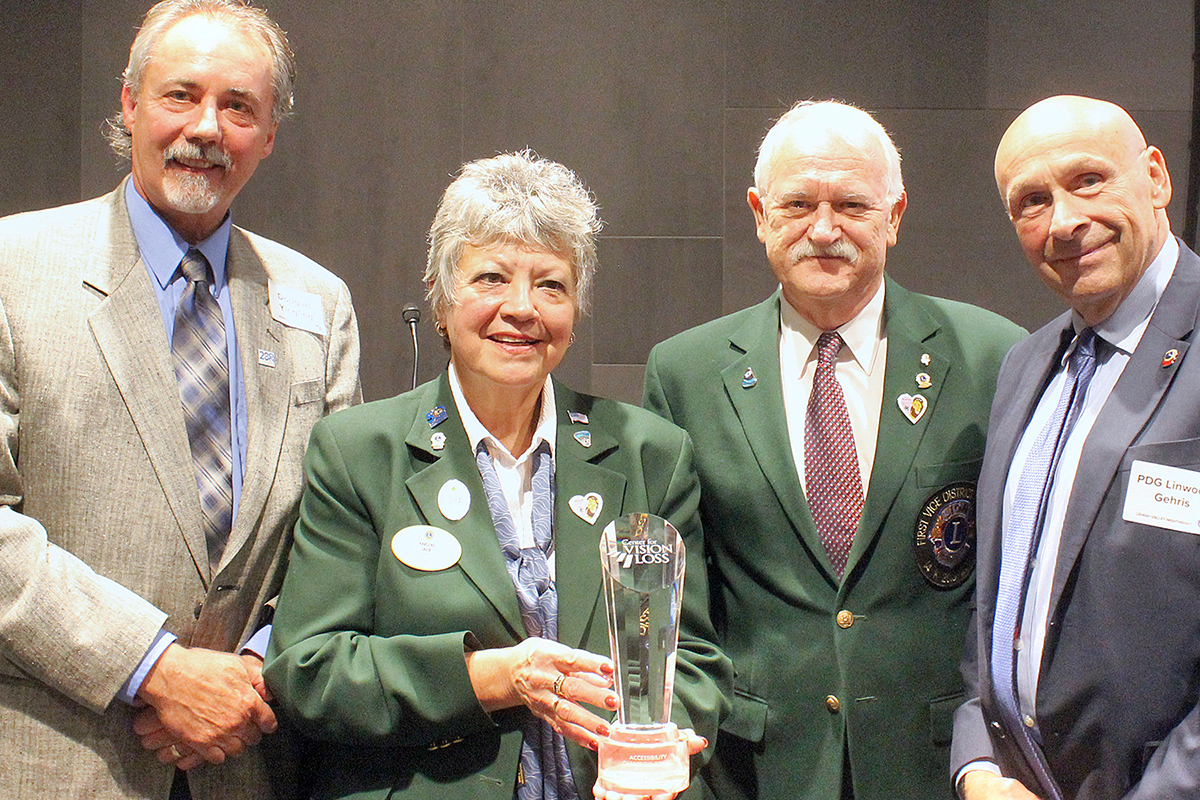 Four people posing with a trophy