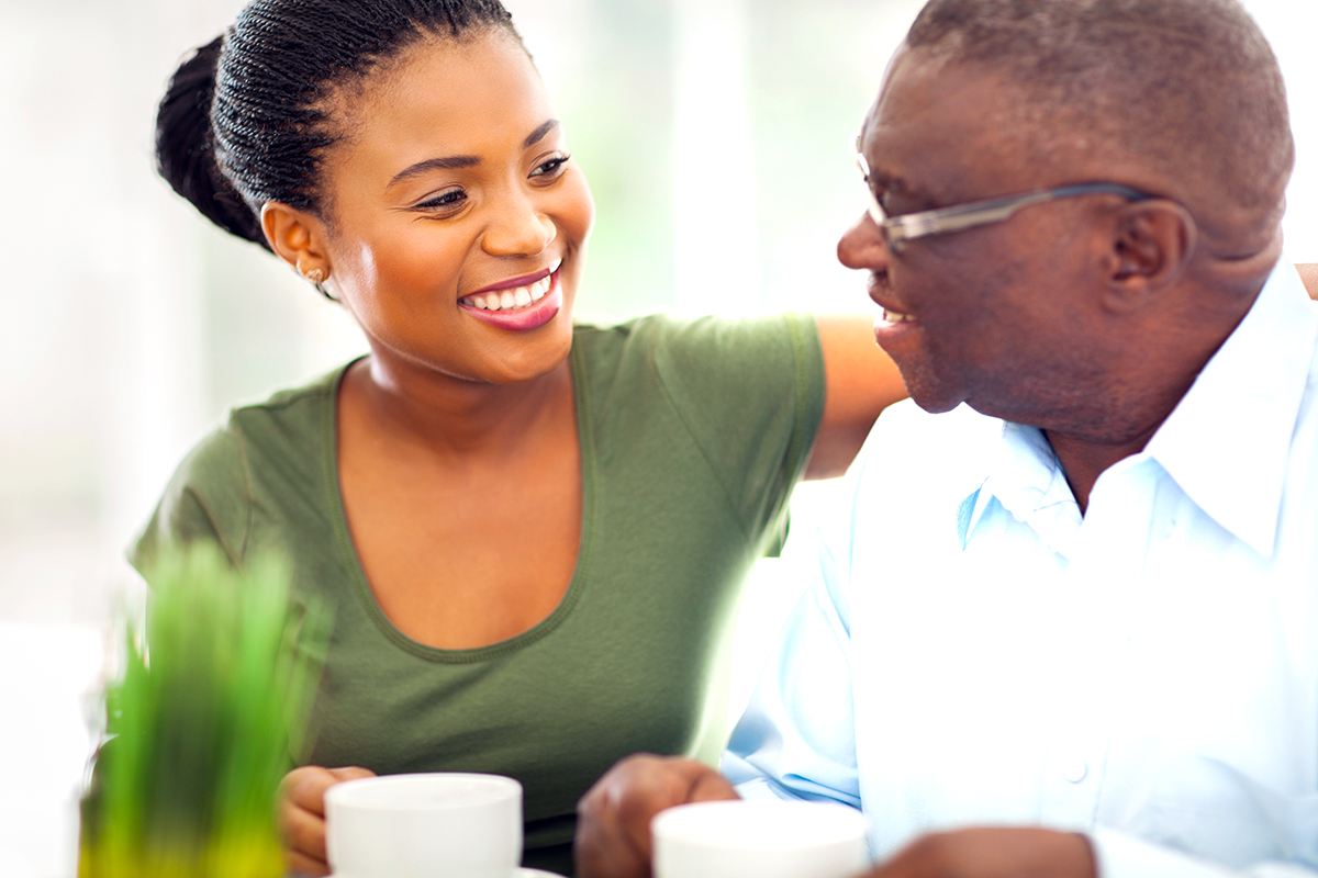 Photo of an older African-American man enjoying coffee with his granddaughter