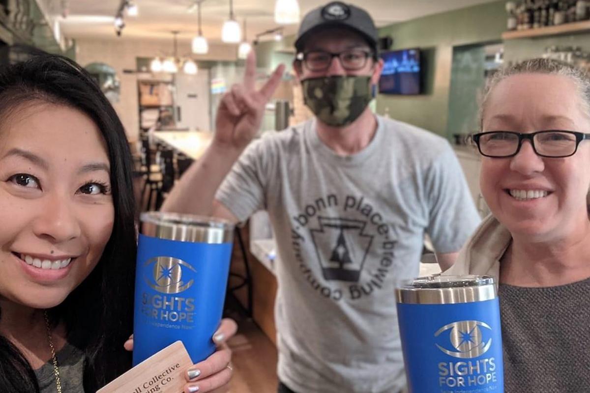 Photo of two people holding Sights for Hope tumblers at McCall Collective Brewing Company