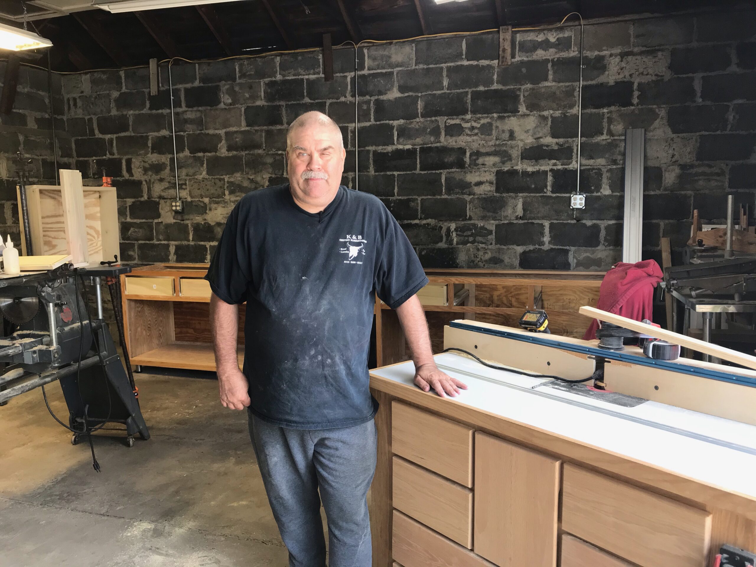 Photo of client Earl standing in his woodshop
