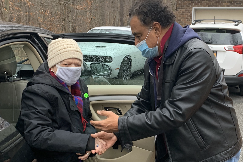 Photo of a Sights for Hope guided transport driver assisting a client as she emerges from a vehicle