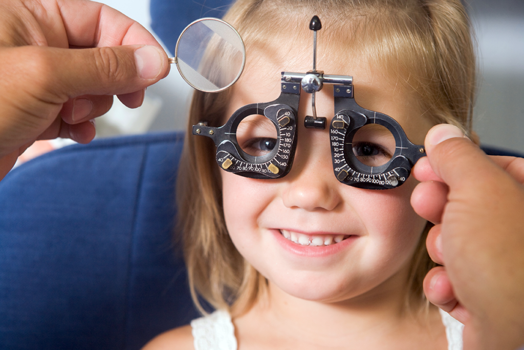 Picture of a young girl receiving an eye exam from a doctor