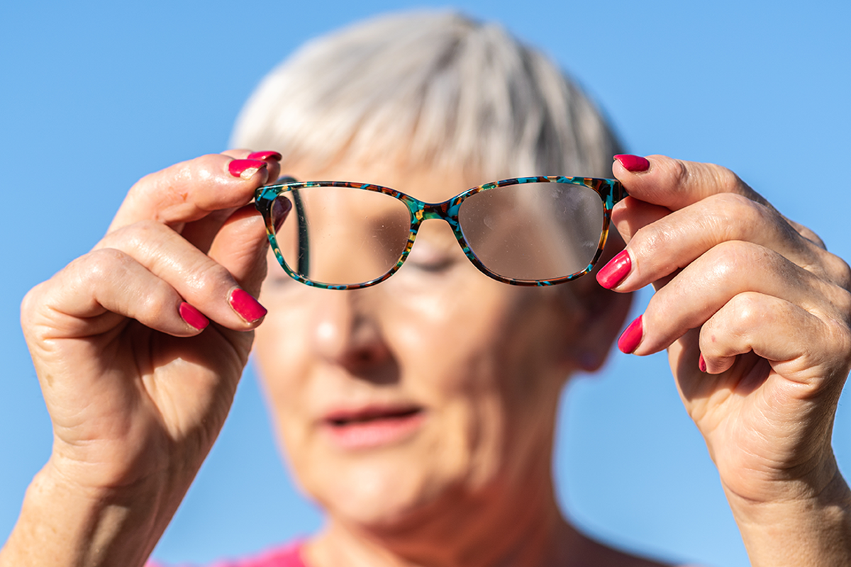 Photo of an older woman holding a pair of glasses