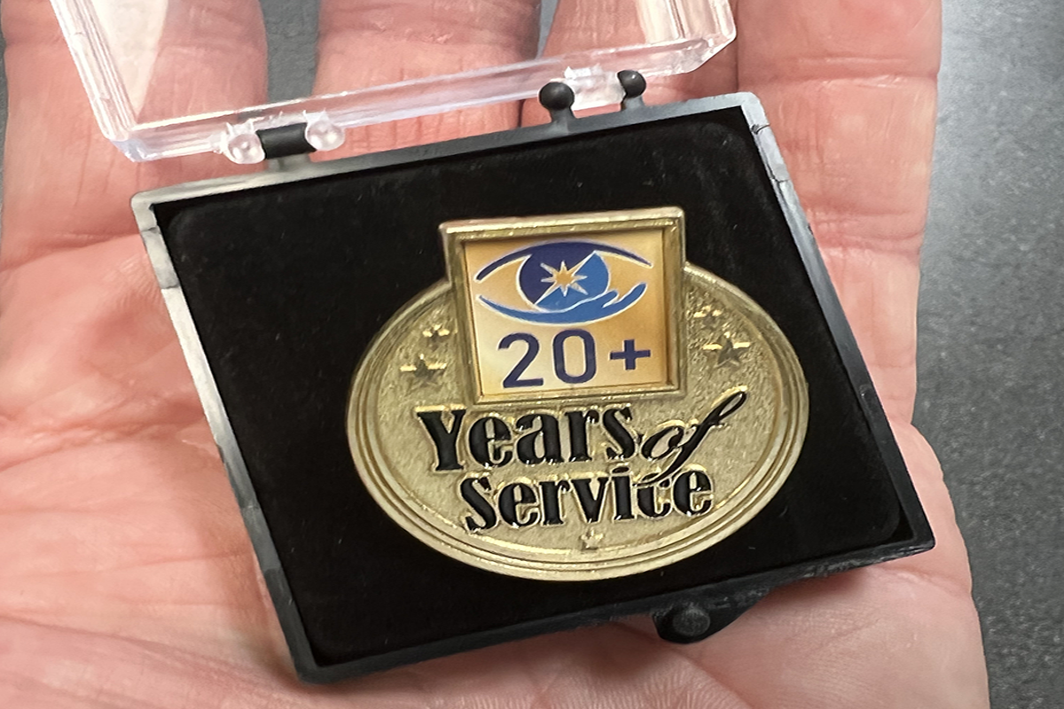 Photo of a Sights for Hope Lifetime of Service Award pin in a man's hand