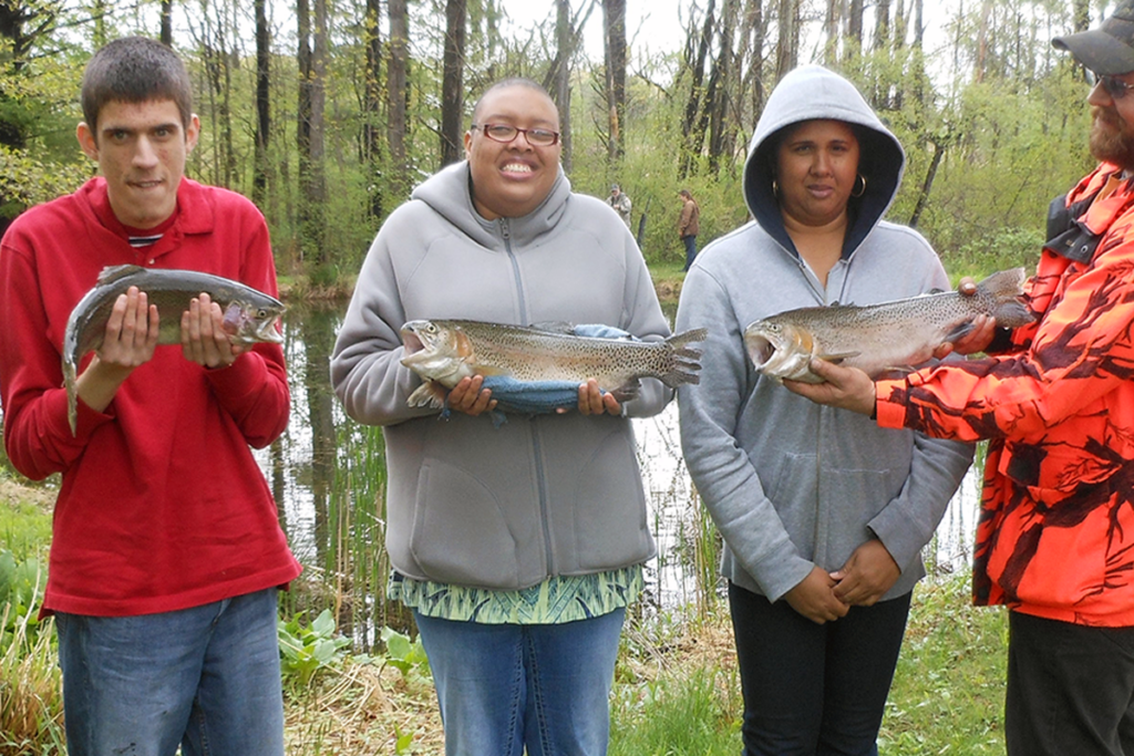 Three Sights for Hope clients pose with fish they caught during a Lions Day of Fishing event