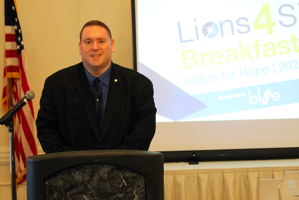 Photo of Dennis Zehner, Executive Director and CEO of Sights for Hope, at the podium during the Lions4Sight 2022 Breakfast