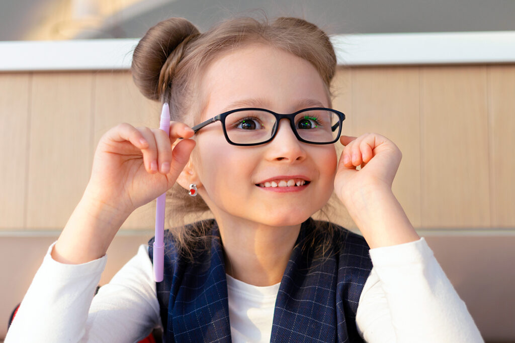 Photo of a female pre-kindergarten child wearing a black pair of glasses