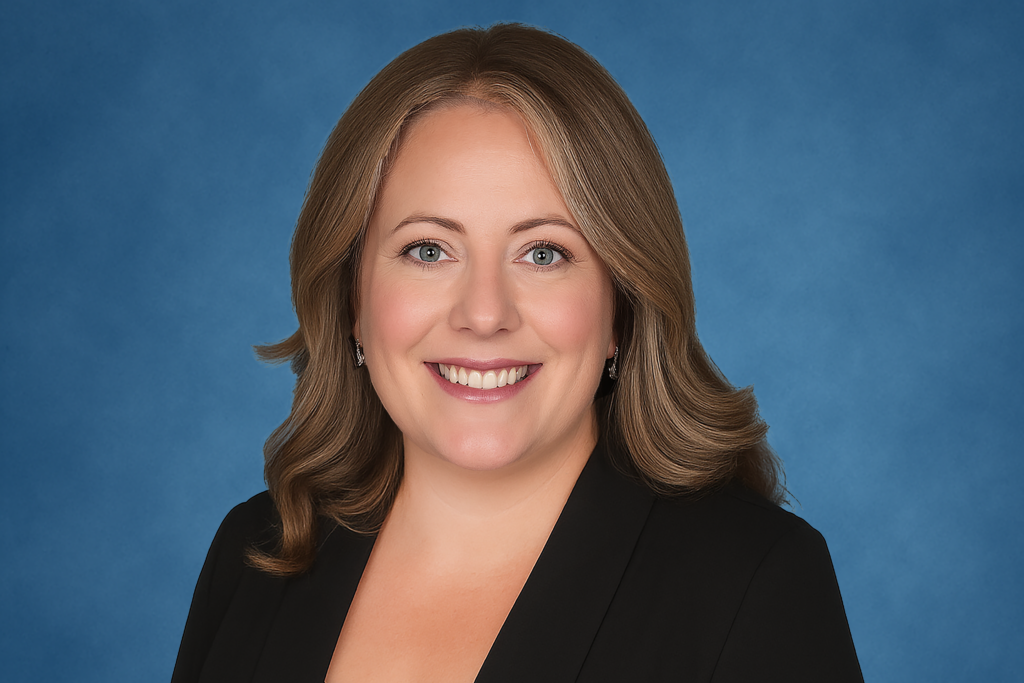 Smiling woman with shoulder-length brown hair, wearing a black top, set against a soft blue background. The tone is professional and approachable.