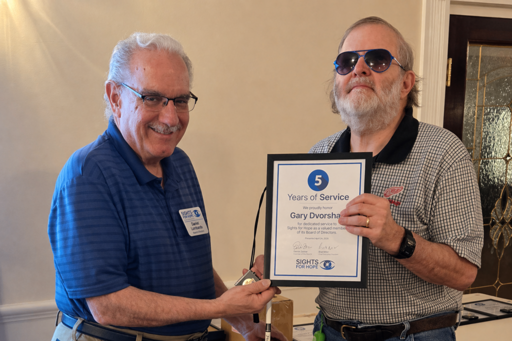 A Sights for Hope team member receiving an award during the Team Appreciation Luncheon, presented by the organization’s Board Treasurer in recognition of their service and contributions.