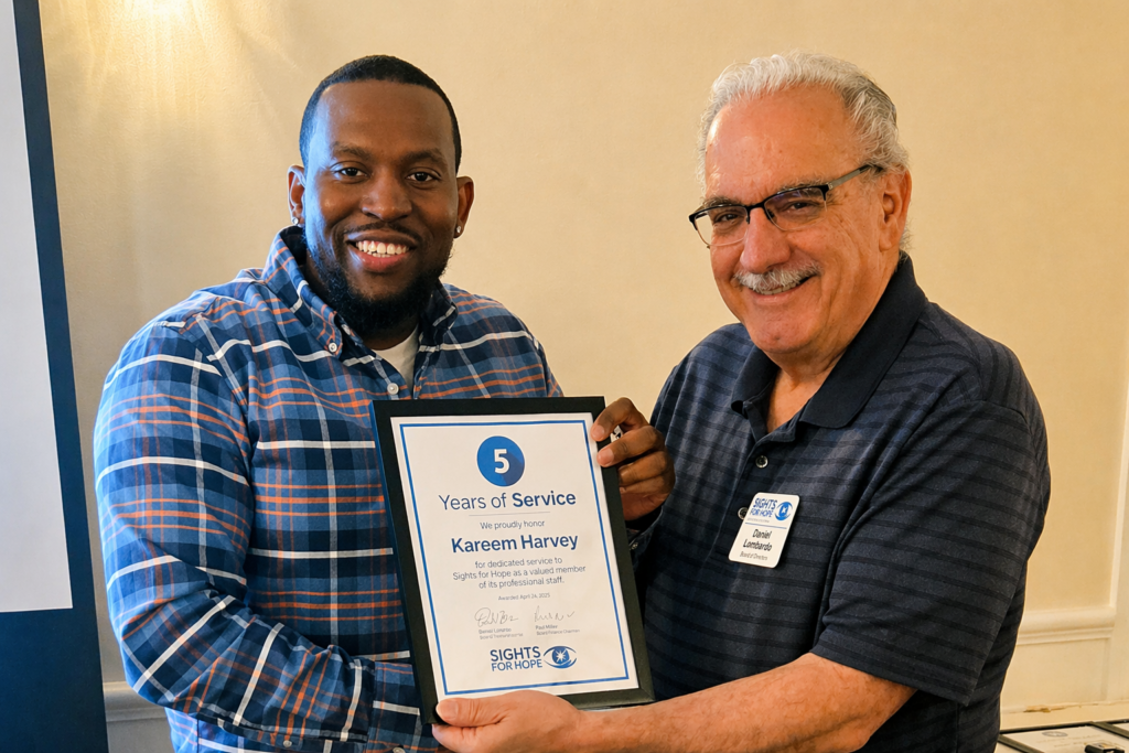 A Sights for Hope team member receiving an award during the Team Appreciation Luncheon, presented by the organization’s Board Treasurer in recognition of their service and contributions.