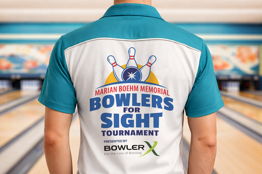 A person wearing an aqua blue and white bowling shirt stands in a bowling alley. The back of the shirt shows a logo that reads "Marian Boehm Memorial Bowlers for Sight Tournament. Presented by BowlerX."