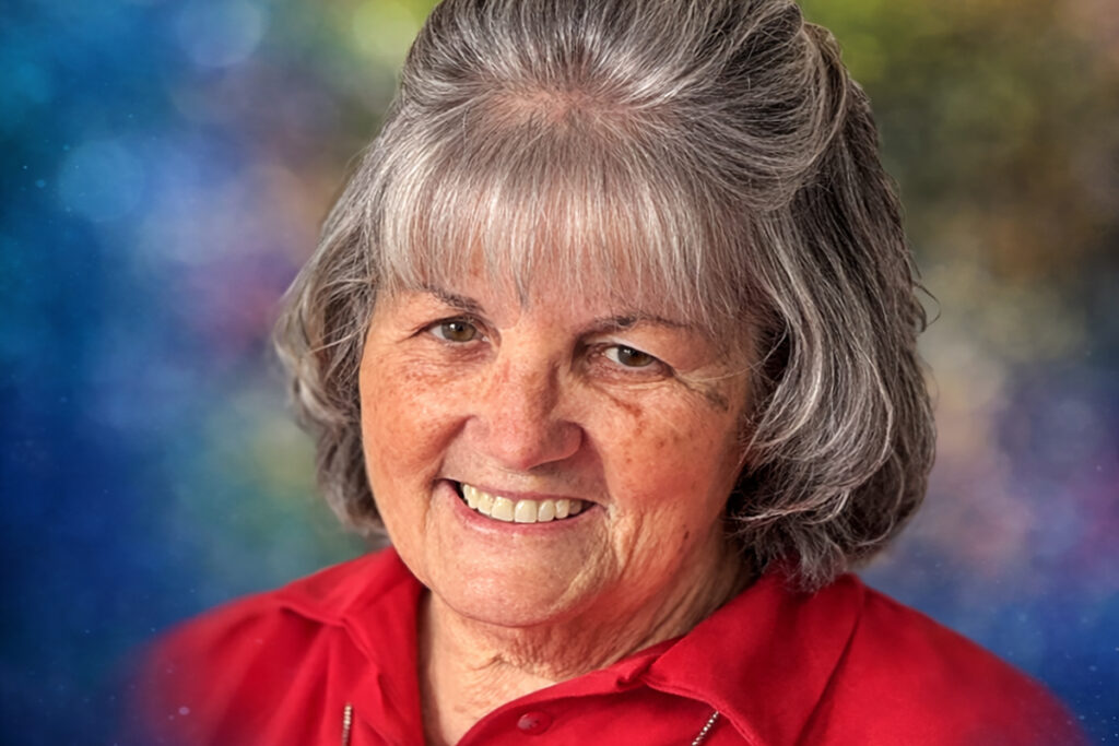 Image of Marian Boehm smiling warmly while wearing red collared shirt.