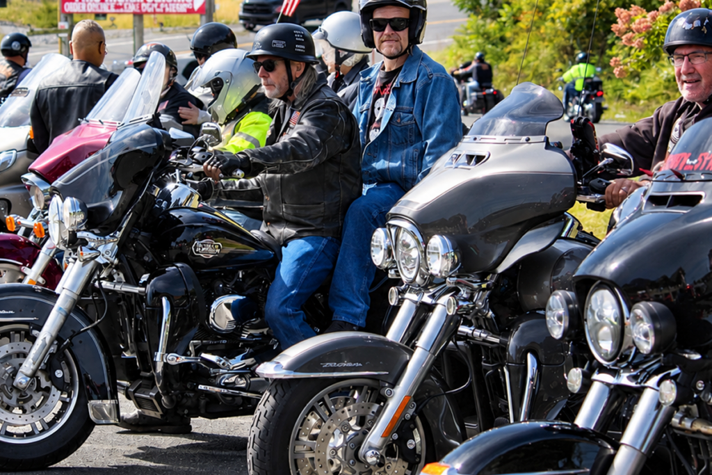 Motorcyclists and Sights for Hope clients wearing helmets and riding gear gather on their motorcycles before the Bikers for Sight Ride. Several large touring motorcycles fill the foreground, with additional riders lined up behind them.