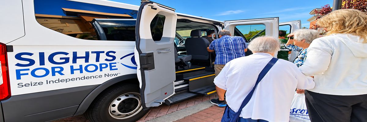 A group of individuals boarding a white van labeled with the Sights for Hope logo.