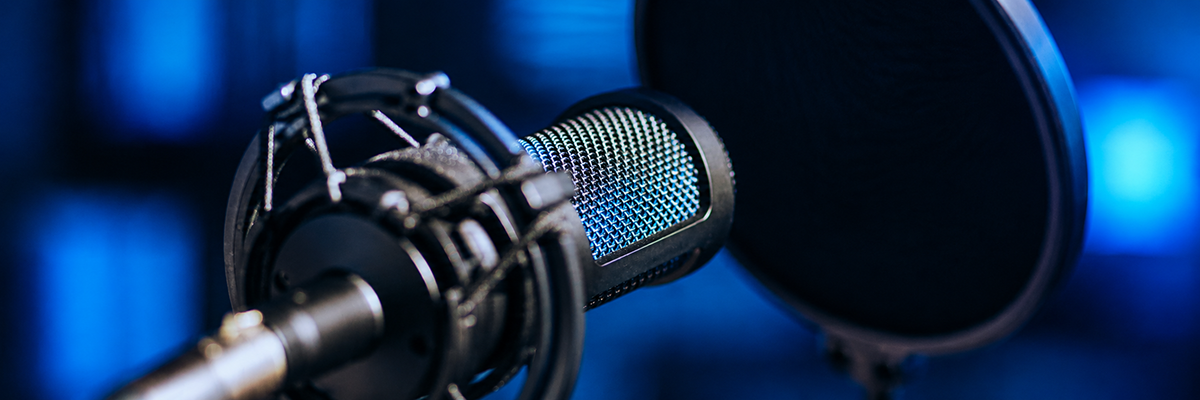 Promotional image of a studio microphone and pop filter against a softly blurred blue background.