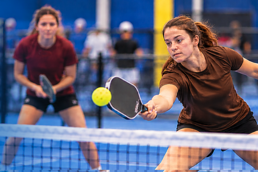 Promotional graphic for the Lehigh Valley Intercollegiate Pickleball Tournament benefiting Sights for Hope. A female pickleball player wearing a brown shirt lunges forward to return a bright yellow ball during an indoor match.